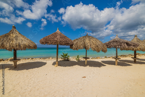 Gorgeous view of sandy Eagle beach turquoise water of Atlantic ocean with sun parasols. Aruba.  © Alex