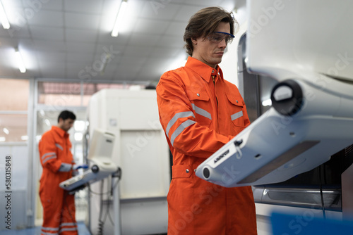 Caucasian engineer man control turning lath machine on monitor at factory