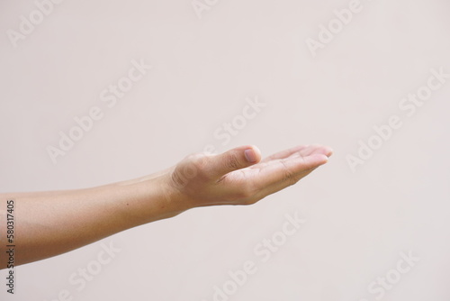 An Asian woman stretches her hand to the side like an empty object on her hand.