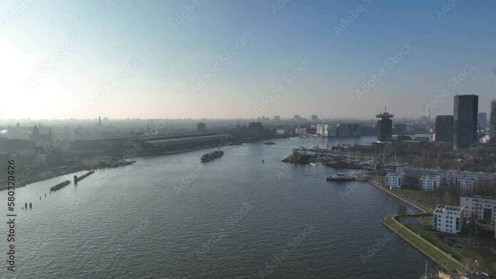 Iconic Amsterdam Central Station stands tall in the center. Iconic Amsterdam Central Station stands tall in the center.