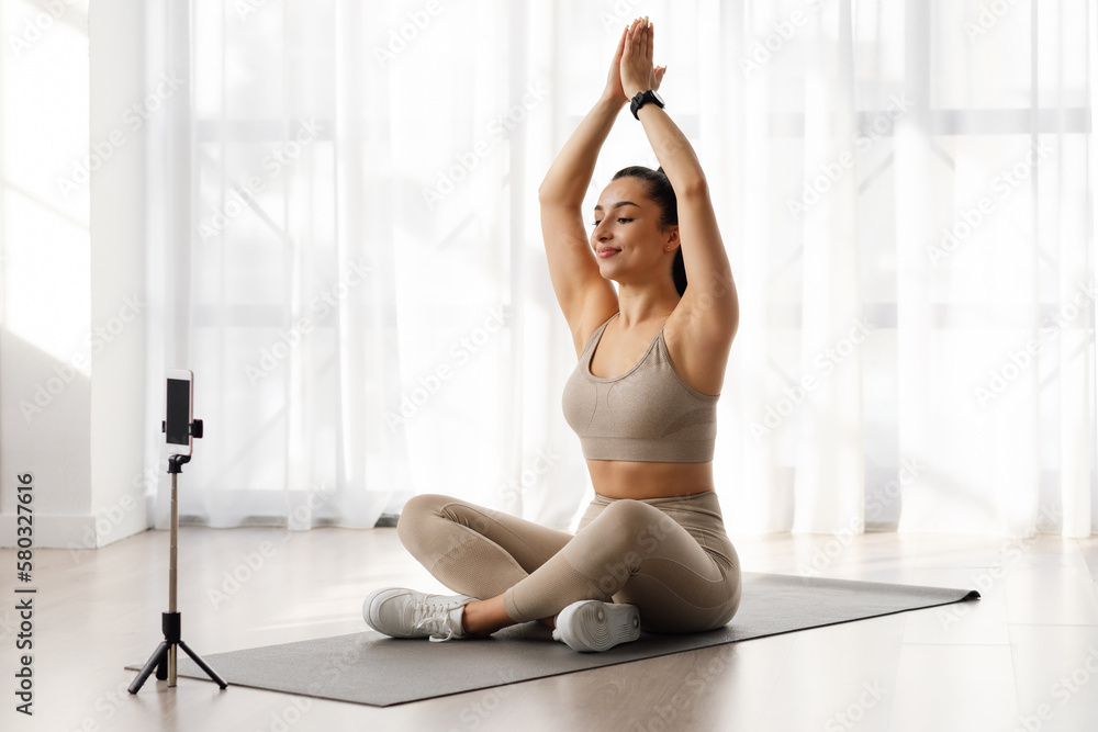 Yoga instructor recording video for online class, using smartphone