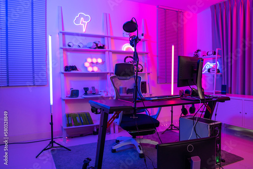Background of gaming room with neon light , live streaming equipment .