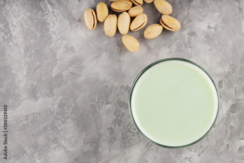 Pistachio milk in a glass on a gray concrete background. Organic lactose free pistachio milk and pistachios. Top view. Copy space Pistachio milk in a glass on a gray concrete background. Organic lactose free pistachio milk and pistachios. Top view. Copy space