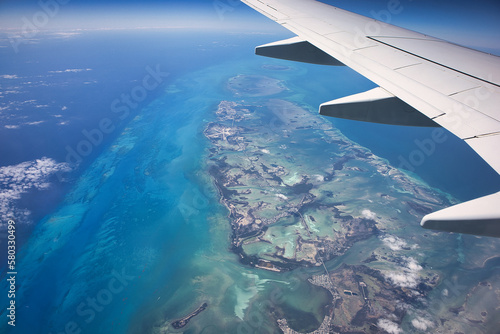 Aerial view from the plane flying across the Caribbean looking down on the Caribbean Sea and the beautiful islands of the tropics in the Bahamas