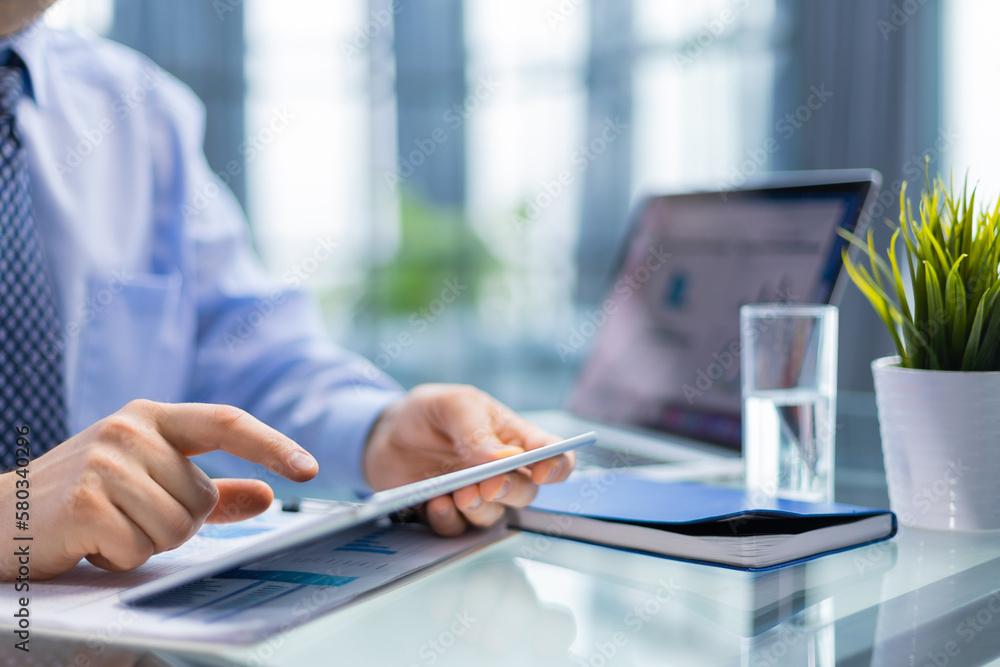Business person analyzing financial statistics displayed on the tablet screen. Business person analyzing financial statistics displayed on the tablet screen.