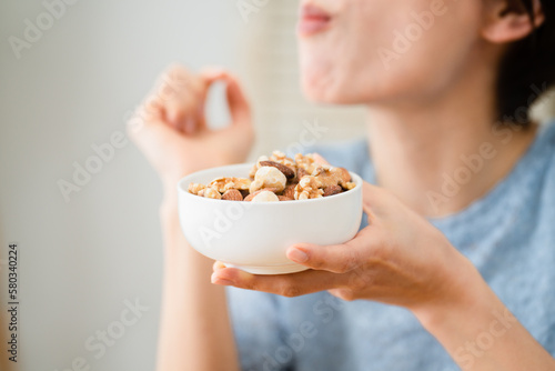 ミックスナッツを食べる若い女性　飲食イメージ photo