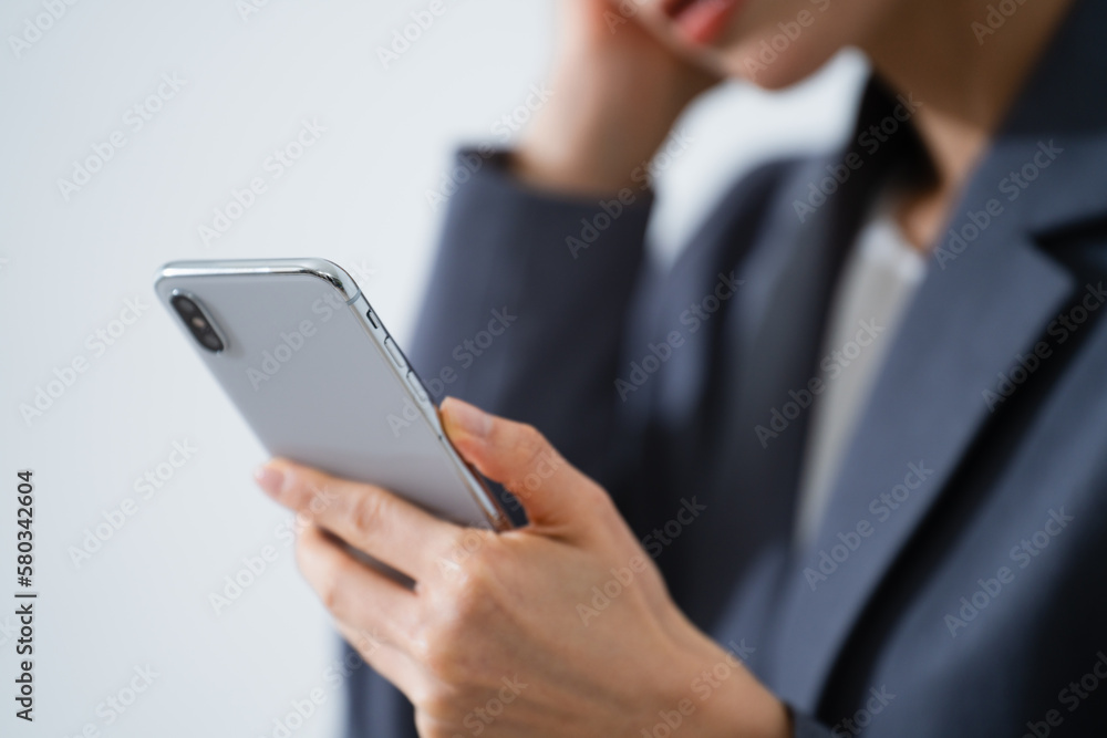 スマートフォンを使う若い女性　ビジネスイメージ