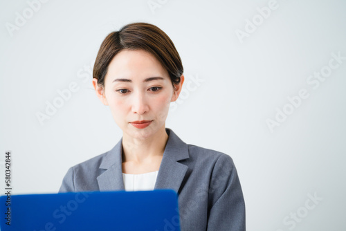 ノートパソコンを使う若い女性 ビジネスイメージ