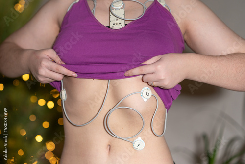 The girl wears a Holter with electrodes on her chest for continuous recording of an electrocardiogram for 24 hours.