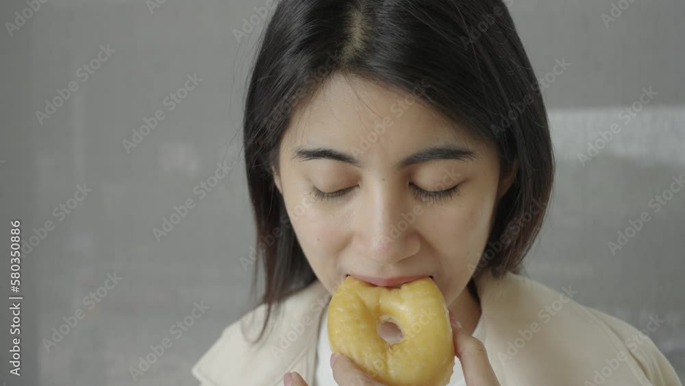 Close-up, Woman eating a donut. Unhealthy diet. Close-up, Woman eating a donut. Unhealthy diet.