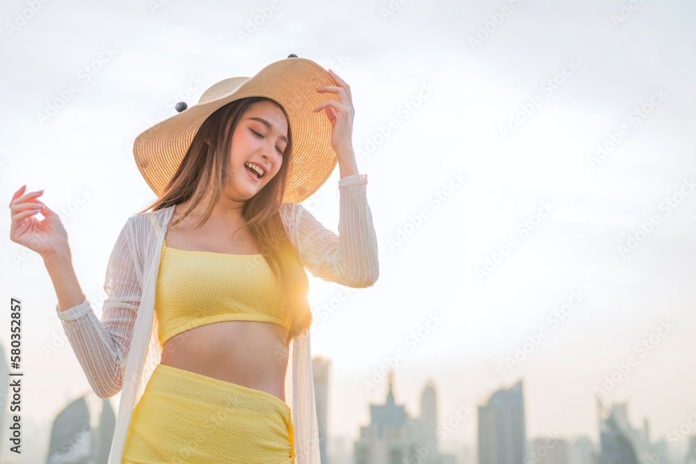 smiling cheerful asian adult woman in bikini relax casual sun bathing on pool bench rooftop swimming pool urban city lifestyle,summer vacation travel ,woman sit on bench happiness peaceful carefree 
