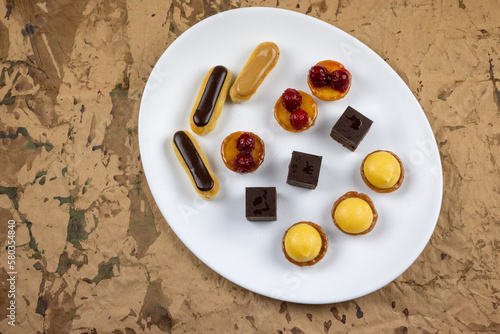petits gâteaux vu de dessus, assiette ovale, fond brun