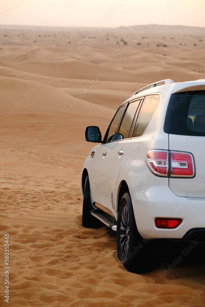 Obraz premium 4x4 vehicle on desert dunes in the evening sun