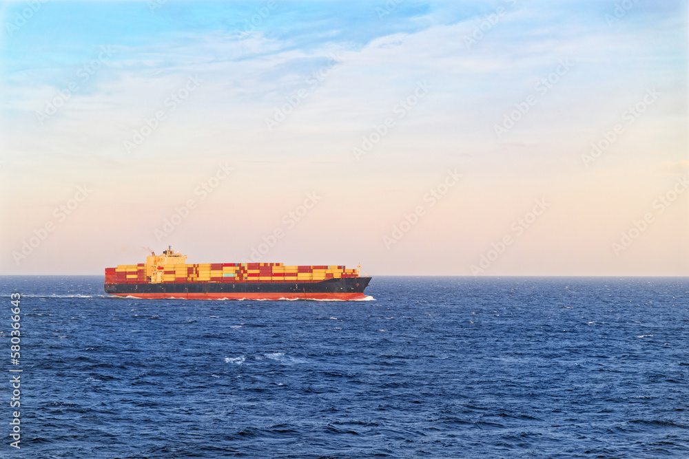 Large cargo ship sailing in open sea on sunny day Large cargo ship sailing in open sea on sunny day