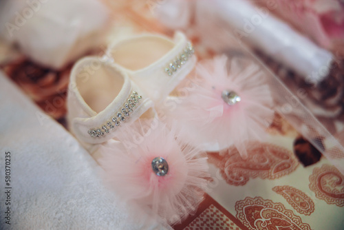 Baby pink shoes set up for a child's orthodox baptism religious ritual. High quality photo