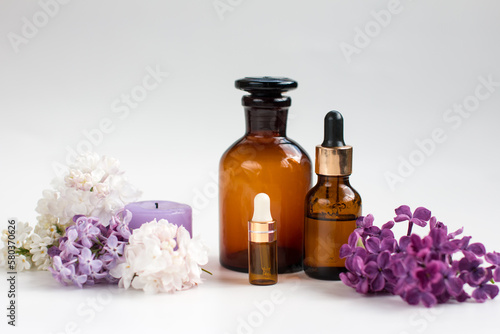 a glass bottle with a pipette for oil and perfume and a fir twig. Aromatherapy, spa salon concept