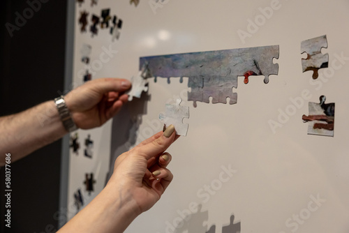 Shuffled magnetic puzzle pieces on a magnet white board waiting to be put together.