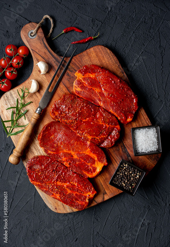 marinated raw pork steaks on stone background