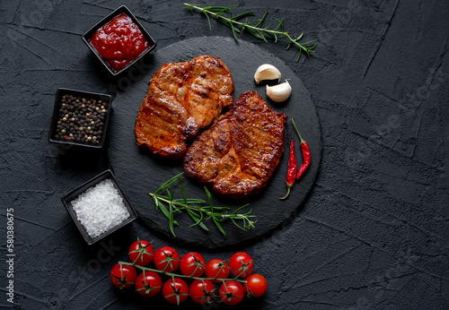 grilled pork steaks on stone background