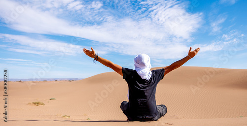 Canvas Print Happy man with white turban in the desert, arms outstretched