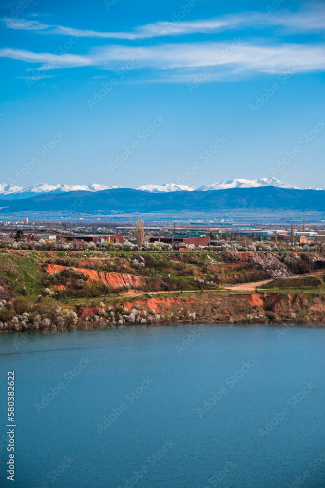 View made over the lake in the former Kremikovtsi mine and views of Sofia and Vitosha Mountain.