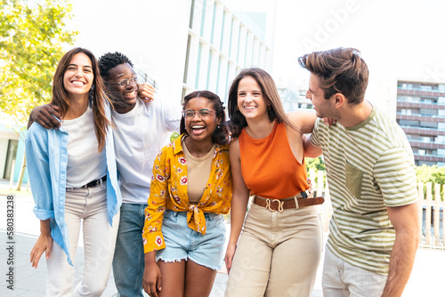 Group of smiling multiracial friends having fun outdoors - Cheerful young people laughing together at city - Friendship concept.