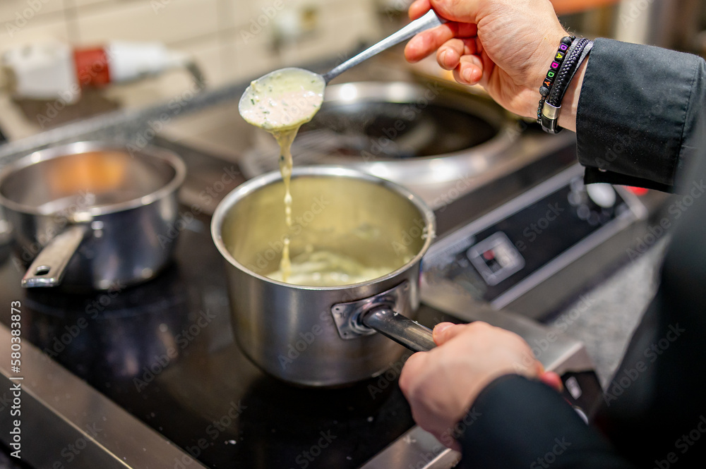 Chef hands cooking sauce in the restaurant kitchen Chef hands cooking sauce in the restaurant kitchen