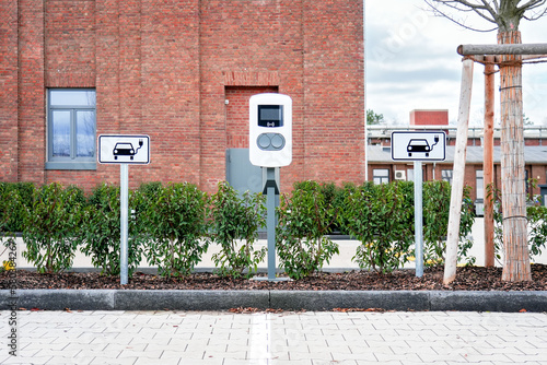 e-car charging station, also known as a e-car charge point or electric vehicle supply equipment (EVSE) with information sign electric car public charging point station and parking spaces photo.