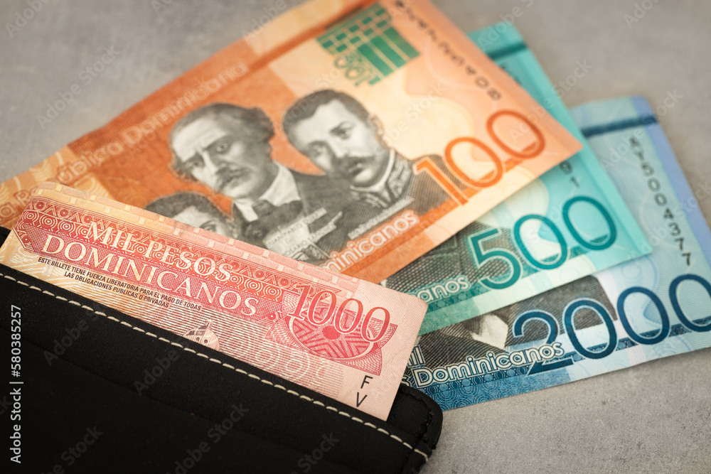 Obraz premium Dominican Republic currency, pesos banknotes, sticking out of wallet, close up, Travel business concept