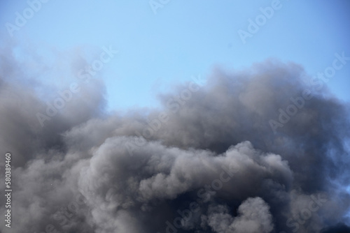 Huge clouds of smoke against the sky, a large fire at a construction site.