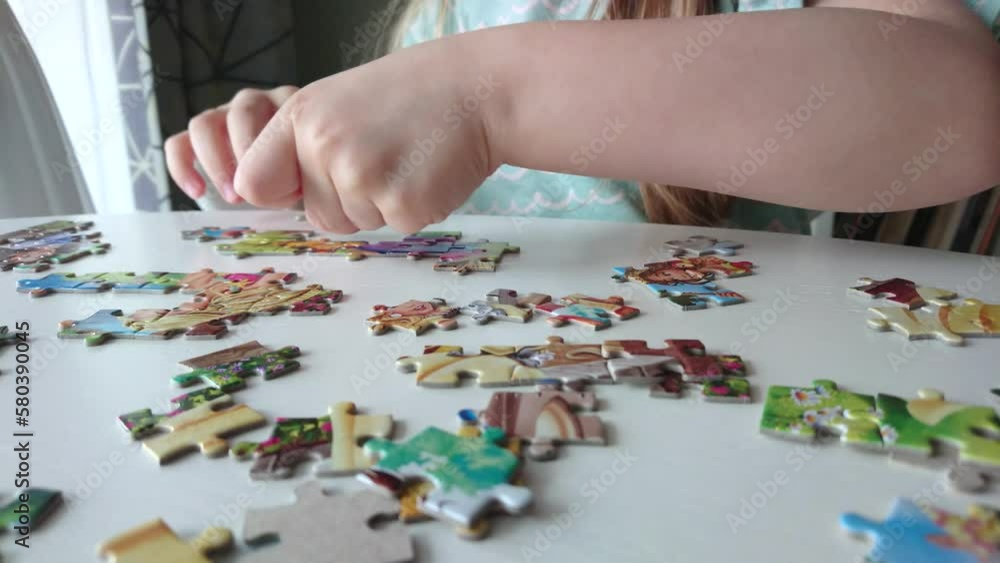 Little child picks up picture from pieces of puzzles Little child picks up picture from pieces of puzzles