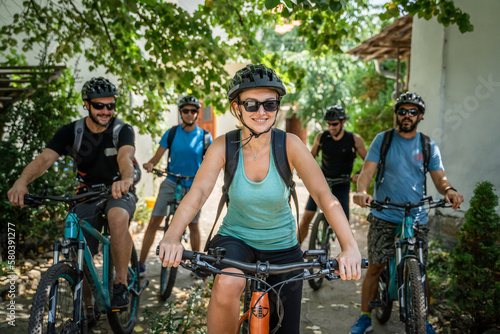 woman and man caucasian friends ride electric bicycle e-bike in summer