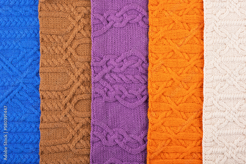 Knitted blue, lilac, brown, orange and beige background. Large knitted fabric with a pattern. Close-up of a knitted blanket. Banner Knitted blue, lilac, brown, orange and beige background. Large knitted fabric with a pattern. Close-up of a knitted blanket. Banner