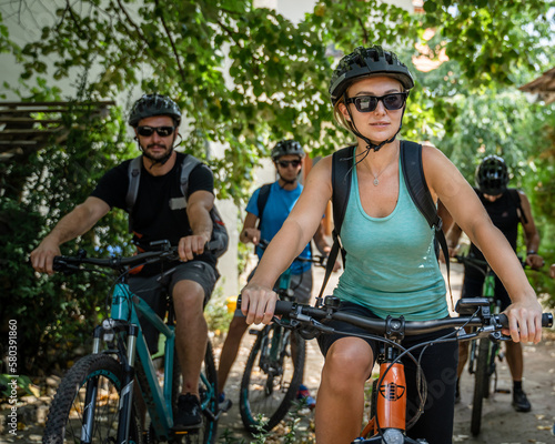 woman and man caucasian friends ride electric bicycle e-bike in summer