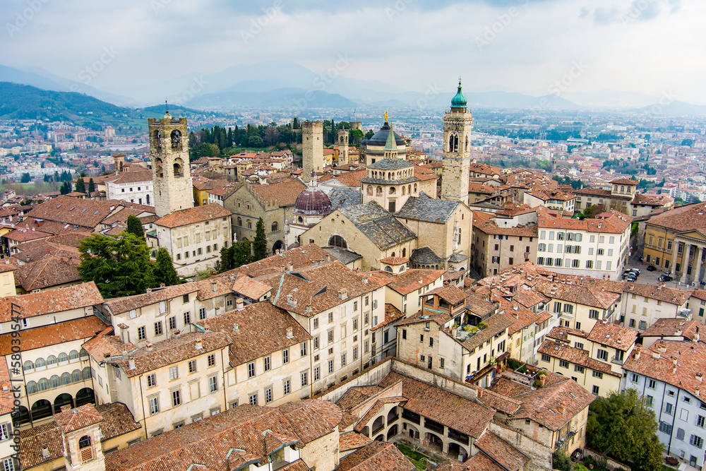 Scenic aerial view of Bergamo city. Flying over Citta Alta, town's upper district, known by cobblestone streets and encircled by Venetian walls. Bergamo, Lombardy, Italy.