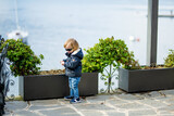 Cute toddler boy having fun exploring on restaurant terrace in Varenna, one of the most picturesque towns on the shore of Lake Como. Varenna, Italy.