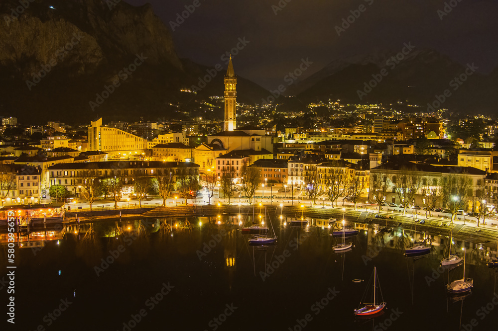 Nighttime aerial cityscape of Lecco town. Picturesque waterfront of Lecco town located between famous Lake Como and scenic Bergamo Alps mountains.