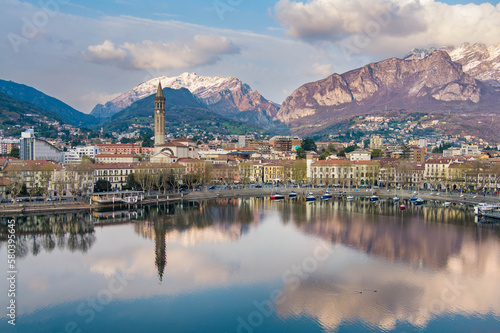 Cloudy aerial cityscape of Lecco town on spring evening. Picturesque waterfront of Lecco town located between famous Lake Como and scenic Bergamo Alps mountains.
