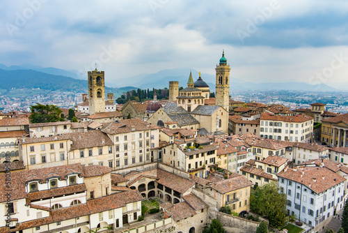 Scenic aerial view of Bergamo city. Flying over Citta Alta, town's upper district, known by cobblestone streets and encircled by Venetian walls. Bergamo, Lombardy, Italy.
