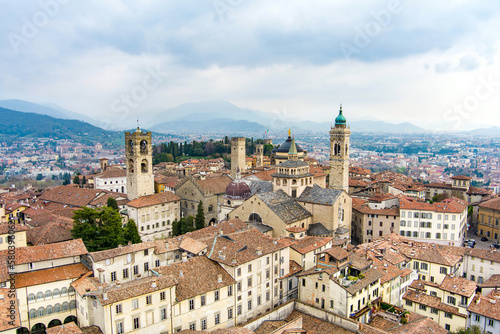 Scenic aerial view of Bergamo city. Flying over Citta Alta, town's upper district, known by cobblestone streets and encircled by Venetian walls. Bergamo, Lombardy, Italy.