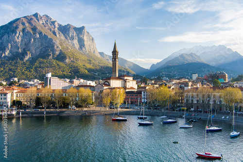 Sunny aerial cityscape of Lecco town on spring morning. Picturesque waterfront of Lecco town located between famous Lake Como and scenic Bergamo Alps mountains.