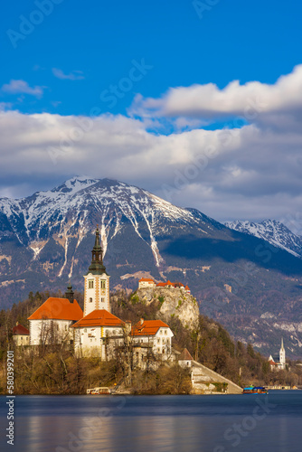 Bled lake with Bled catle, church and winter Julian Alps at background