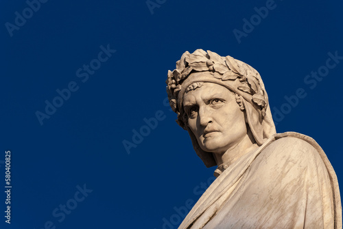 Dante Alighieri the greatest italian poet. Marble statue erected in Florence Santa Croce square in 1865 (with blue sky and copy space)