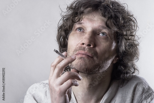Obraz na plátně a man of Slavic appearance with curly hair and a cigarette in a thoughtful pose