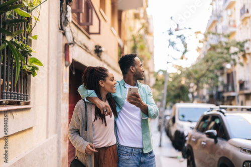 Photography couple tourists in the city - african american travelers with smart phone