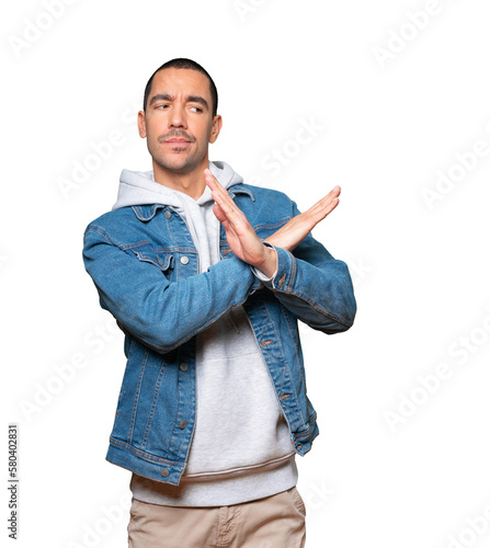 Young man making a gesture of not crossing with the arms