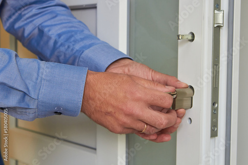 installing a lock on a plastic door,a professional locksmith repairs a door in an office, door repair