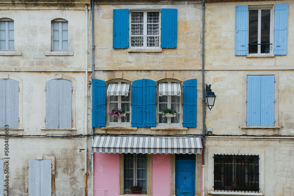 Old exterior vintage house in Italy with blue and pink window shutters