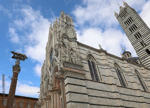 cathedral of SIENA in central Italy with the bell tower and the statue of the she-wolf with Romulus and Remus photo