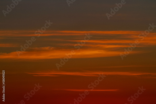 Orange sunset sky with thin cloud lines. Abstract colour tones